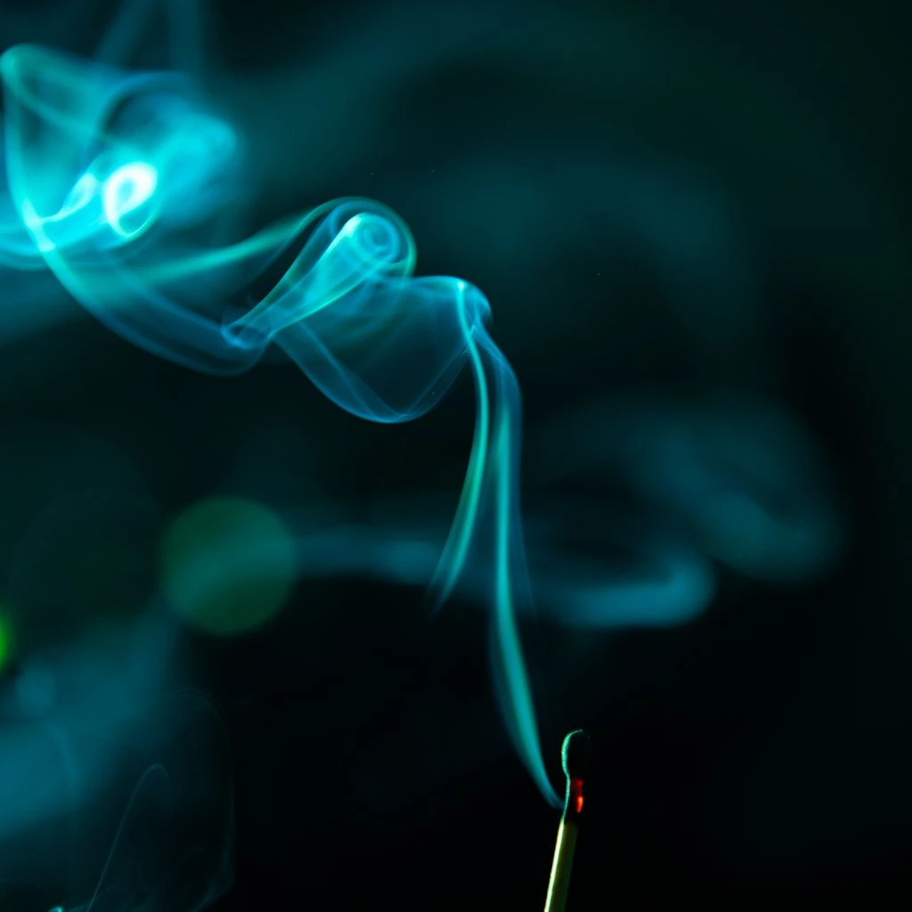 Charred incense and blackened glass representing the smoky family.